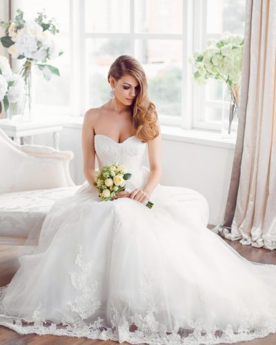bride-in-beautiful-dress-sitting-resting-on-sofa-indoors